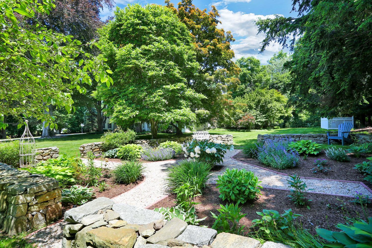 109 Rosebrook Road New Canaan, CT 06840 - Photo 36 of 47 a view of a garden with a bench