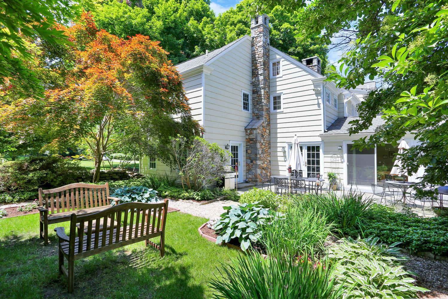 109 Rosebrook Road New Canaan, CT 06840 - Photo 4 of 47 a view of a chair and table in the backyard
