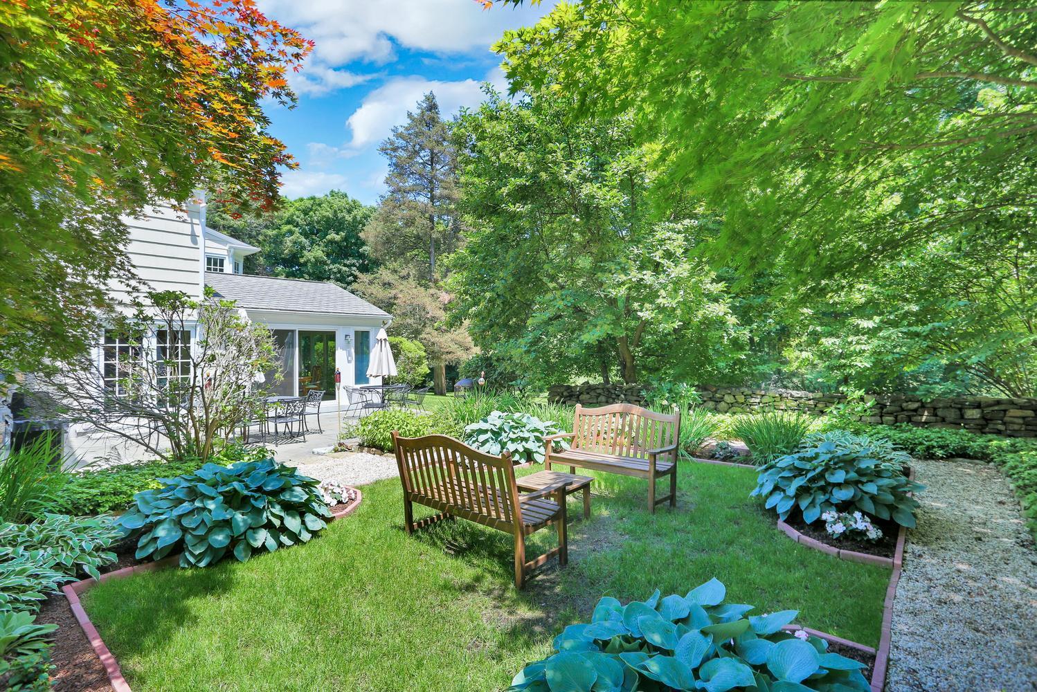 109 Rosebrook Road New Canaan, CT 06840 - Photo 5 of 47 a view of a chair and table in backyard of the house