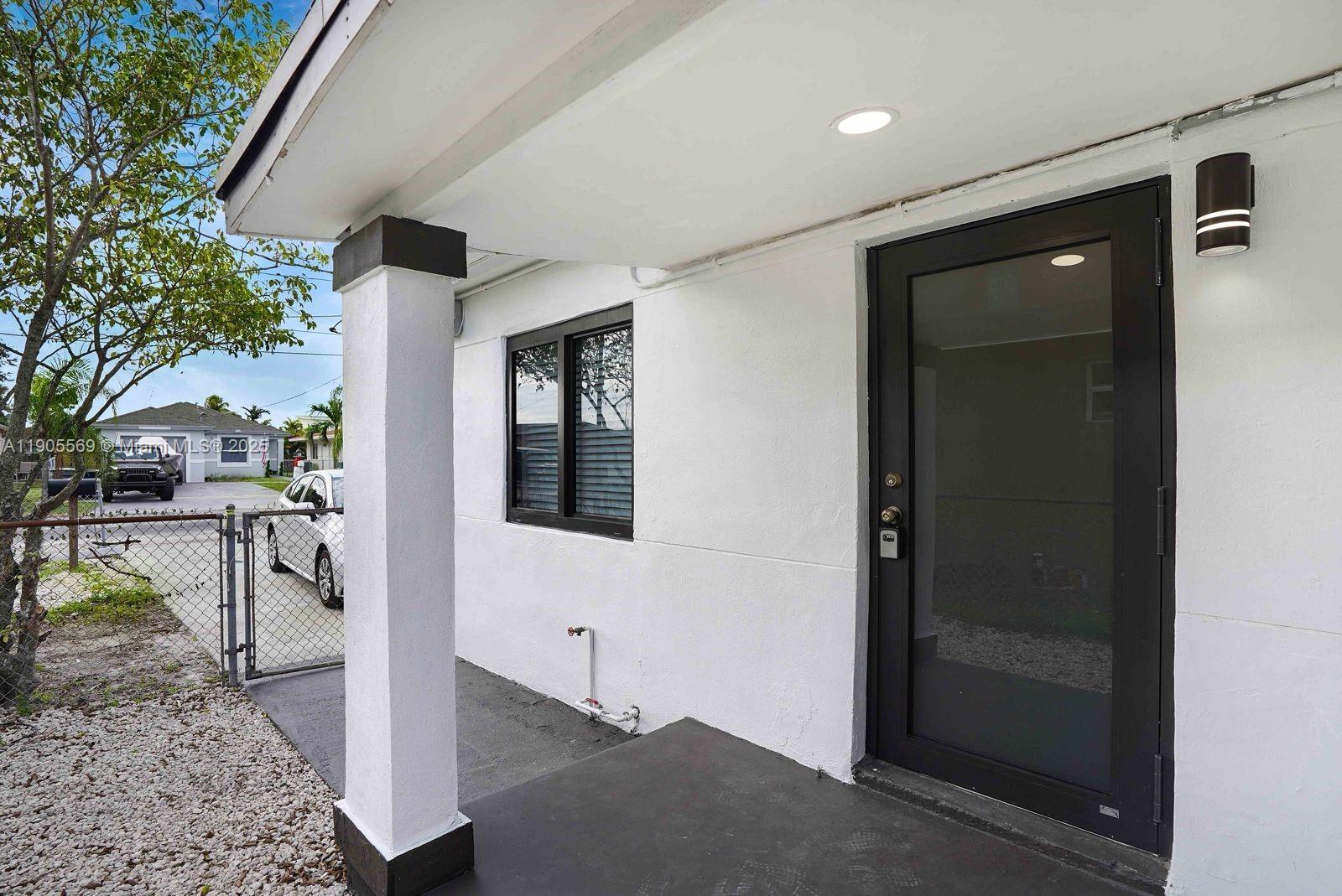 502 Northwest 7th Court, Unit 2 Hallandale Beach, FL 33009 - Photo 2 of 19 a front view of a house with a yard