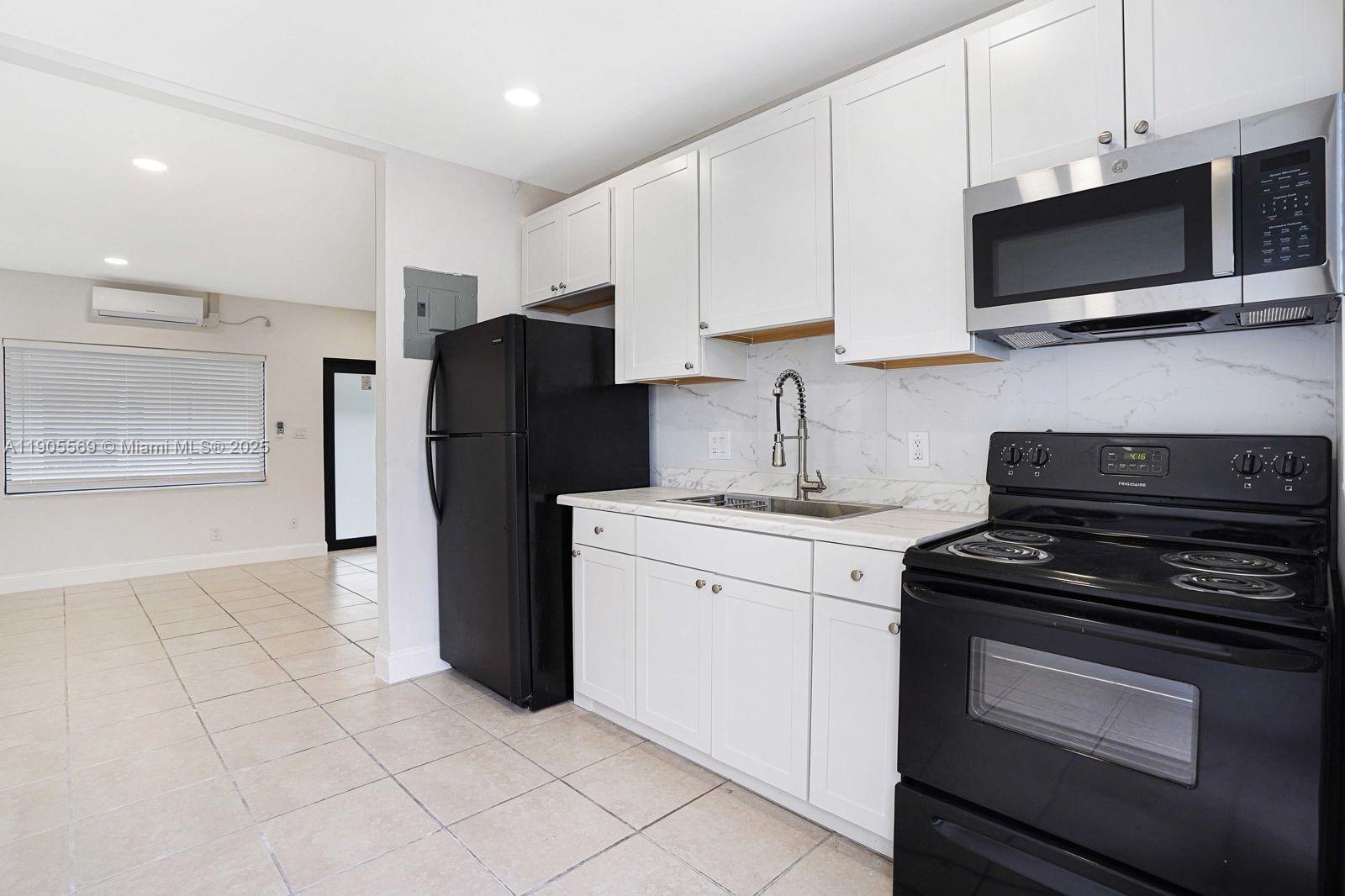 502 Northwest 7th Court, Unit 2 Hallandale Beach, FL 33009 - Photo 3 of 19 a kitchen with a refrigerator stove and cabinets