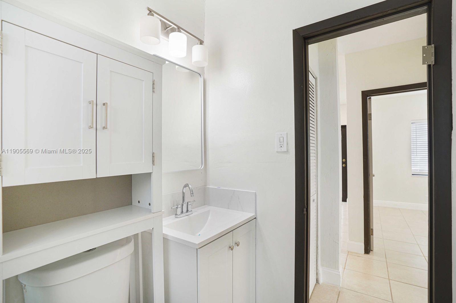 502 Northwest 7th Court, Unit 2 Hallandale Beach, FL 33009 - Photo 6 of 19 a kitchen with a sink and a mirror