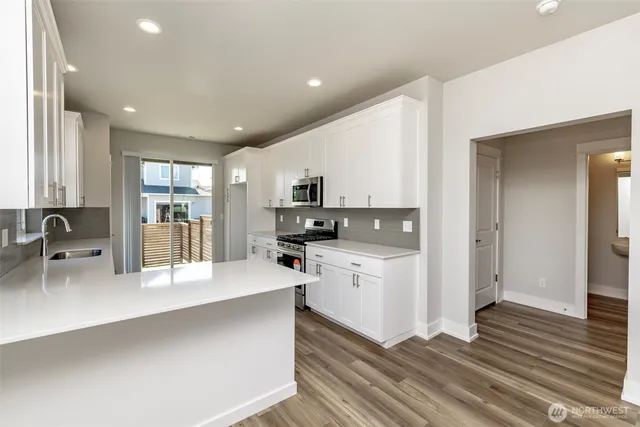a large white kitchen with stainless steel appliances