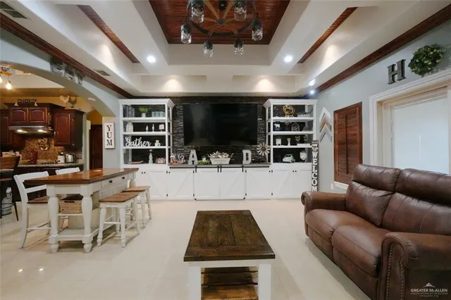 a living room with furniture a flat screen tv and kitchen view