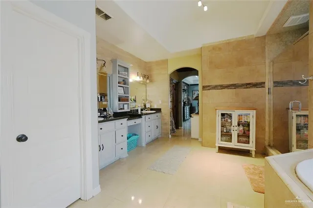 a large bathroom with a tub a sink and a large mirror