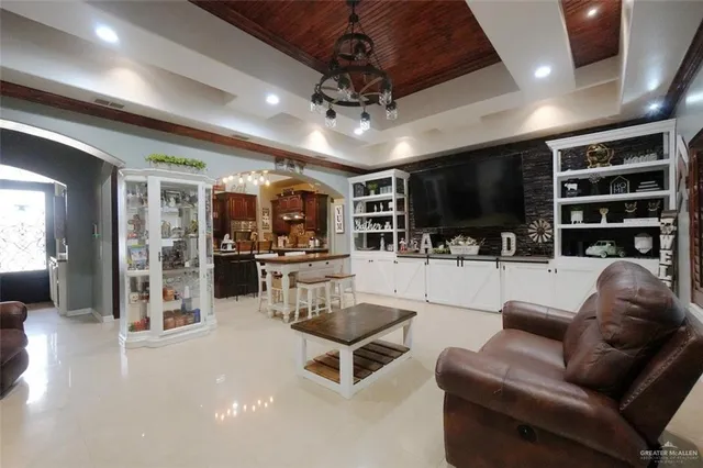 a living room with furniture a flat screen tv and kitchen view