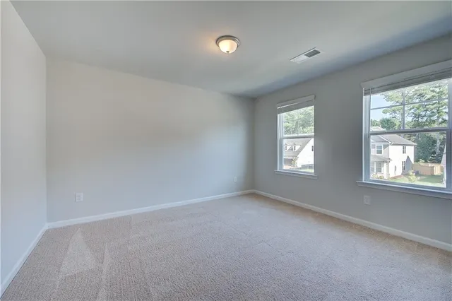 an empty room with a window and a chandelier fan