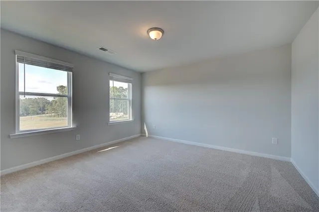 an empty room with windows and ceiling fan