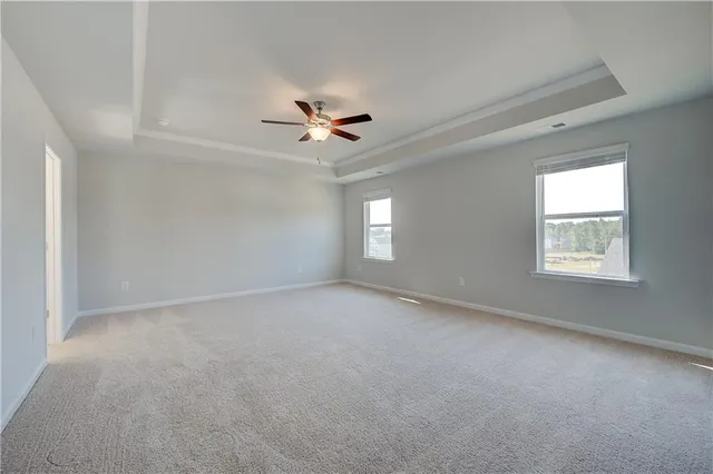 a view of an empty room and a ceiling fan