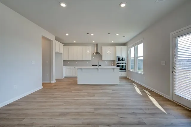 a view of kitchen with kitchen island sink refrigerator and window