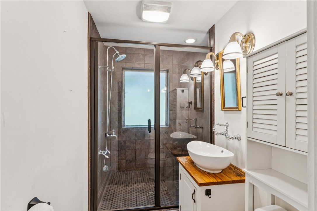 321 South Pine Street Walhalla, SC 29691 - Photo 19 of 32 A well-appointed bathroom with a spacious glass-enclosed shower and a vessel sink atop a charming vanity.