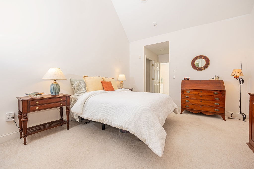 50 Stratford Ridge, Unit 50 Mashpee, MA 02649 - Photo 8 of 30 a bedroom with a bed and a chandelier