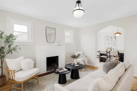 a living room with furniture a fireplace and a chandelier