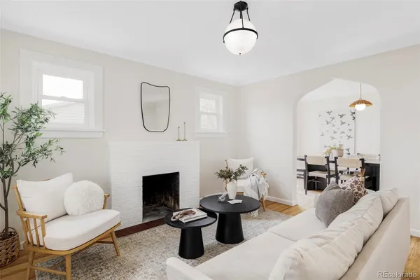 a living room with furniture a fireplace and a chandelier
