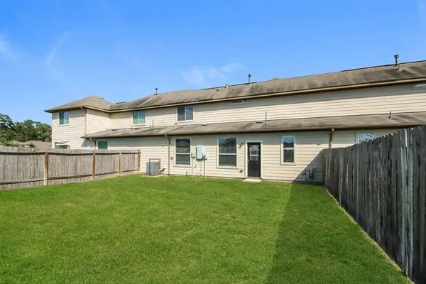 a view of a house with a yard and a large tree
