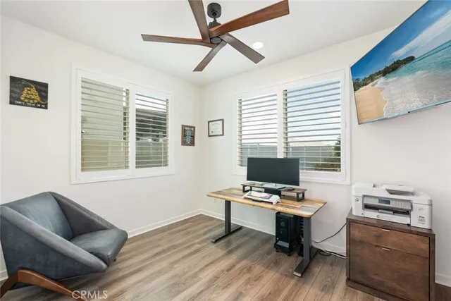 a work room with furniture wooden floor and a window