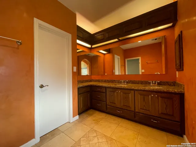a bathroom with a granite countertop sink and a mirror