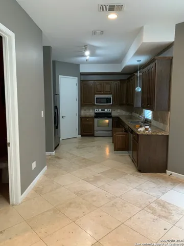 a kitchen with stainless steel appliances granite countertop a stove and a refrigerator