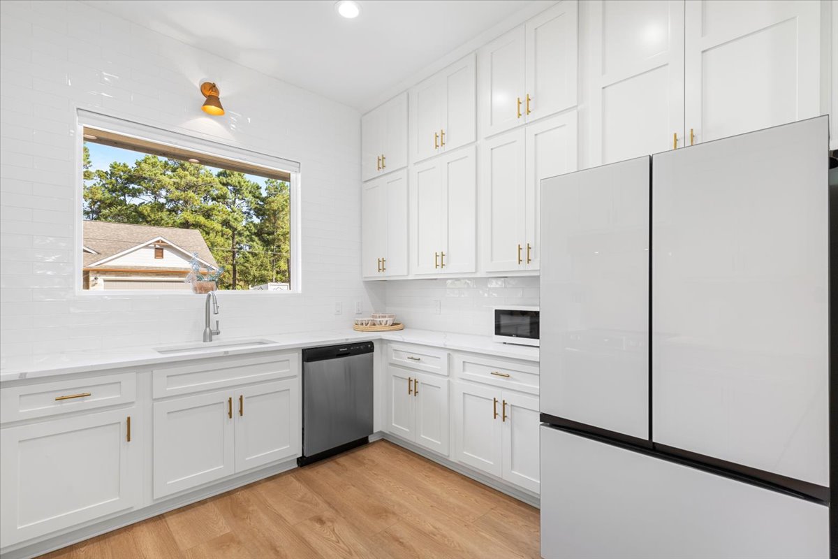 133 Lake Point Way Bastrop, TX 78602 - Photo 12 of 34 a kitchen with white cabinets and window