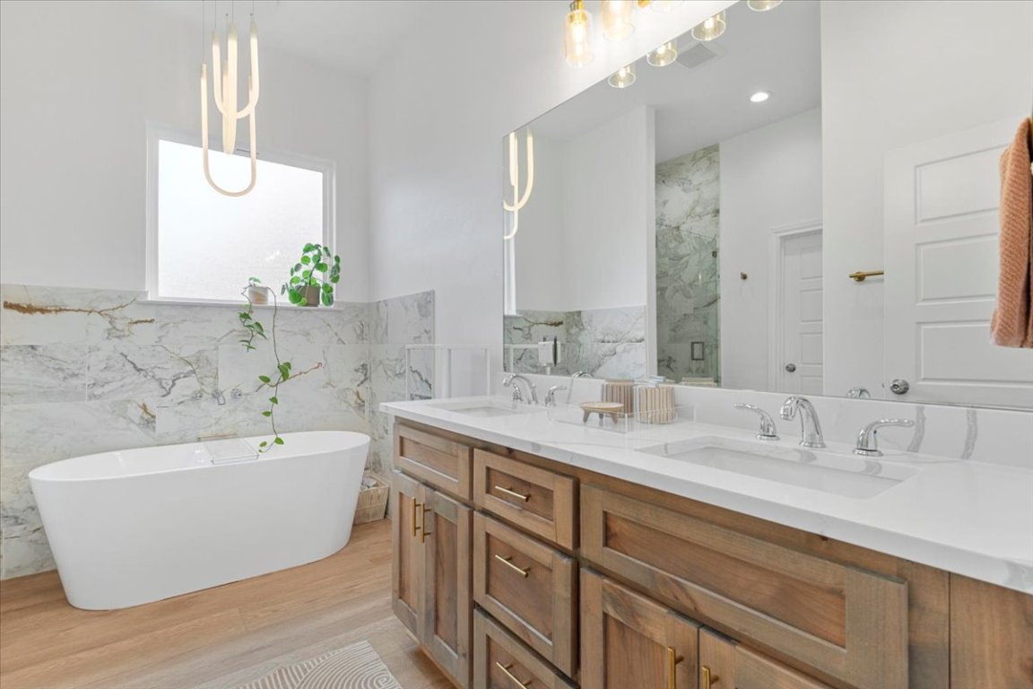 133 Lake Point Way Bastrop, TX 78602 - Photo 17 of 34 a bathroom with a double vanity sink and a bathtub