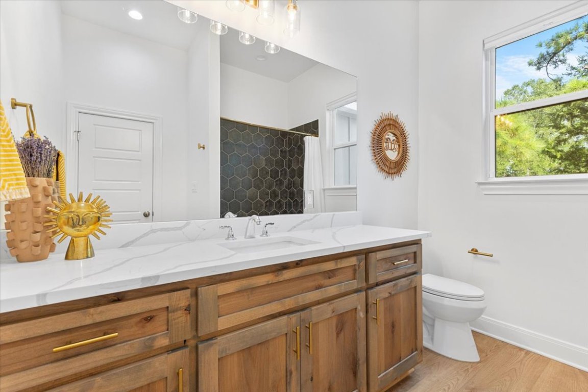 133 Lake Point Way Bastrop, TX 78602 - Photo 24 of 34 a bathroom with a granite countertop sink a toilet and a mirror