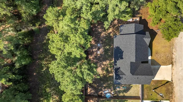 an aerial view of residential house with outdoor space and trees all around
