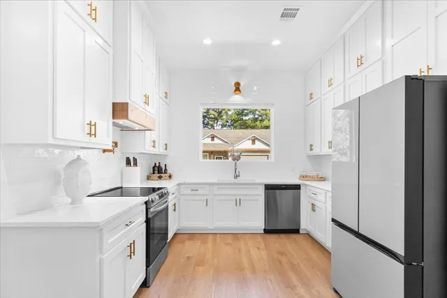 a kitchen with white cabinets and white appliances