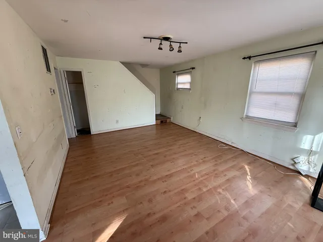 a view of a livingroom with wooden floor and stairs