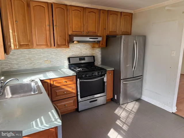 a kitchen with stainless steel appliances granite countertop a refrigerator sink and stove