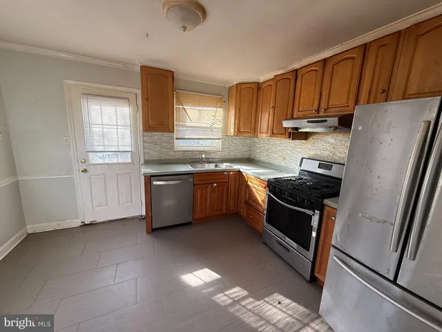 a kitchen with stainless steel appliances wooden cabinets and a sink