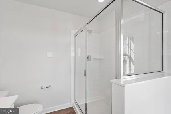 a bathroom with a shower a toilet and a window