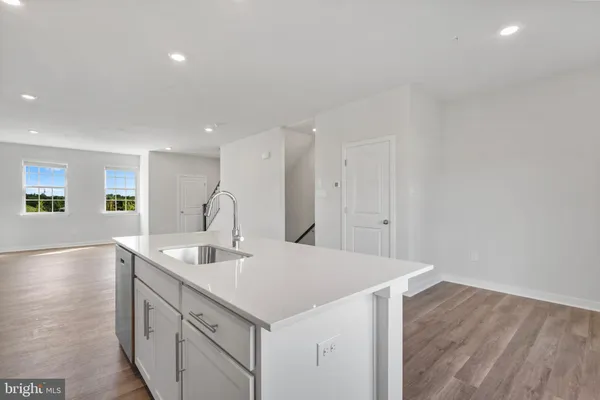 a kitchen with a sink cabinets and wooden floor