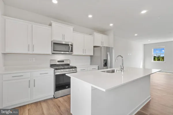 a kitchen with stainless steel appliances white cabinets and a sink