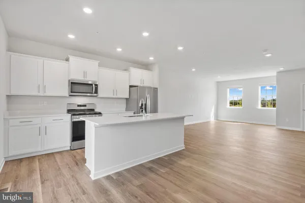 a kitchen with stainless steel appliances a refrigerator sink and microwave