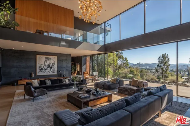 a living room with furniture ceiling fan and a large window