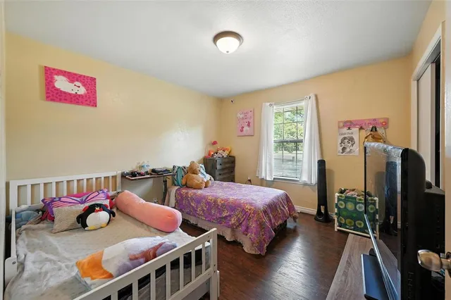 a bedroom with two beds and a wooden floor