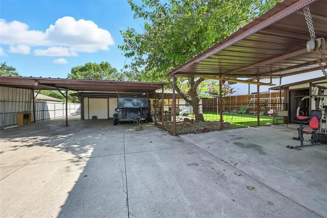 a view of a patio with table and chairs under an umbrella