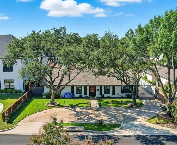a view of a white house with a big yard and large trees