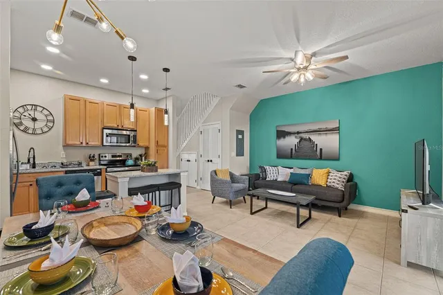 a kitchen with granite countertop stainless steel appliances a refrigerator a stove a sink cabinets and a dining table