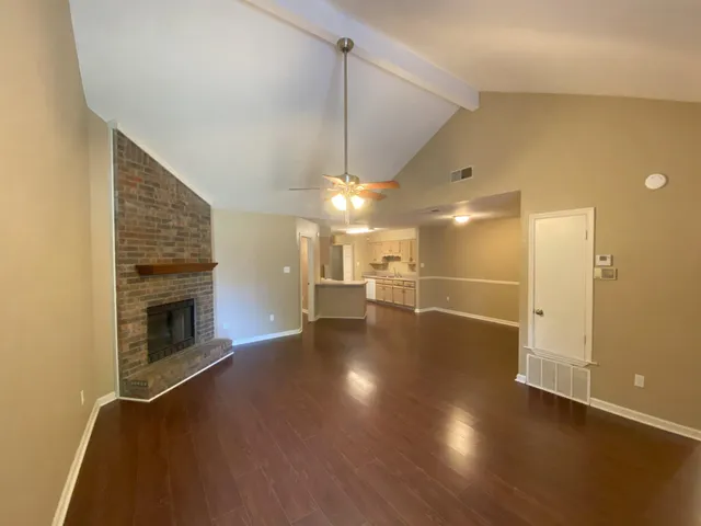 a view of a livingroom with wooden floor and a fireplace