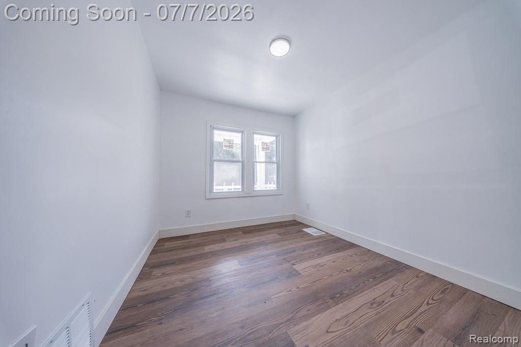 18486 Trinity Street Detroit, MI 48219 - Photo 8 of 19 Bright room featuring wood-finish flooring, crisp white walls, white baseboards, and a contemporary flush-mount ceiling light