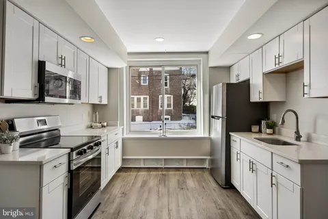 a kitchen with stainless steel appliances a stove sink cabinets and refrigerator