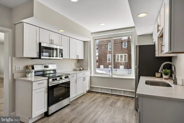 a kitchen with granite countertop a stove top oven sink and cabinets