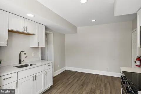 a kitchen with a sink cabinets and wooden floor