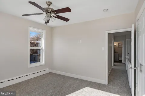 an empty room with fan and windows