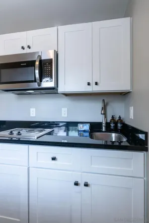 a kitchen with stainless steel appliances granite countertop white cabinets and sink