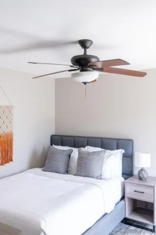 a bedroom with a bed and a ceiling fan