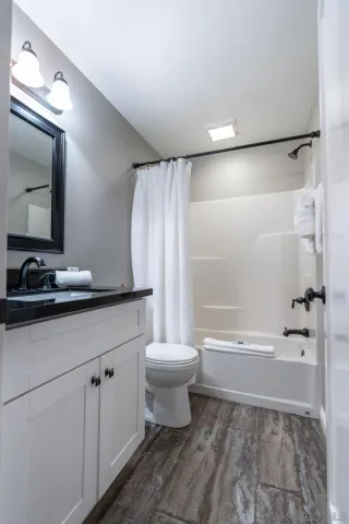 a bathroom with a granite countertop sink a toilet and a mirror