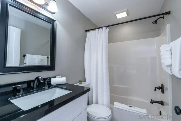 a bathroom with a granite countertop sink toilet and shower