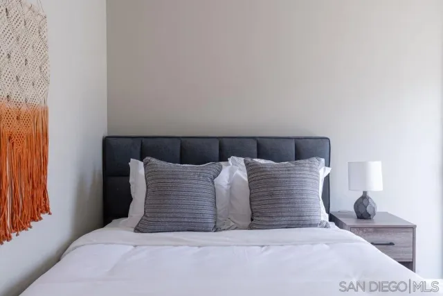 a large bed sitting in a bedroom and lamp next to a window